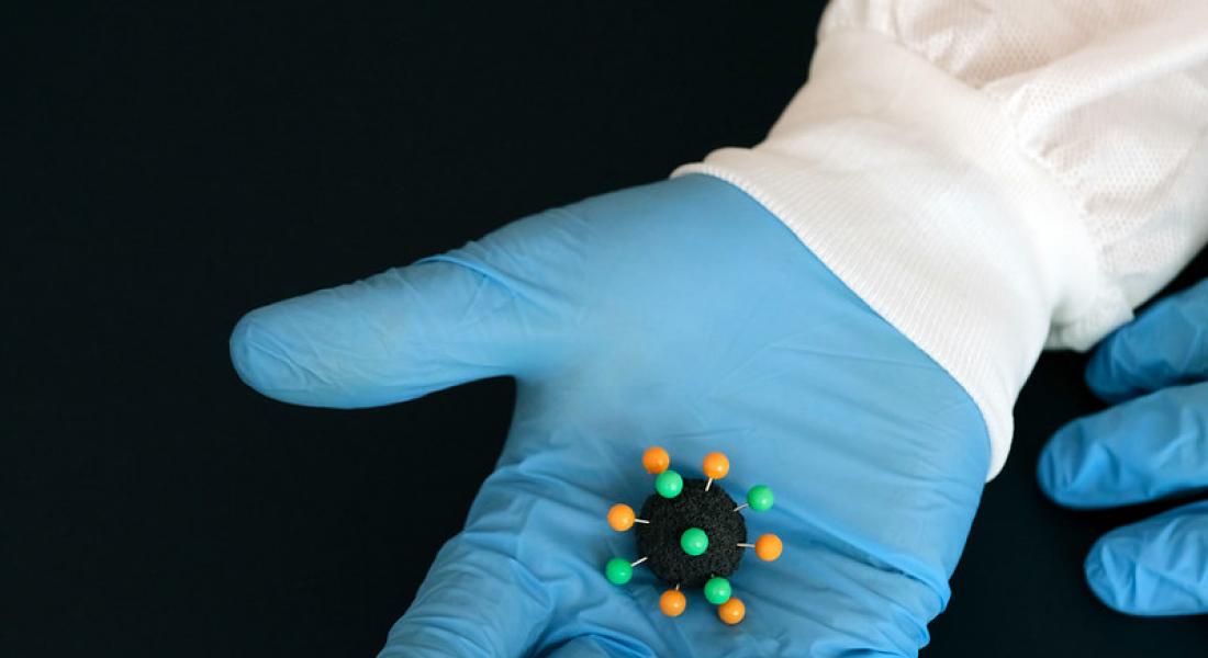Lo que sería un virus sobre una mano con guantes de latex