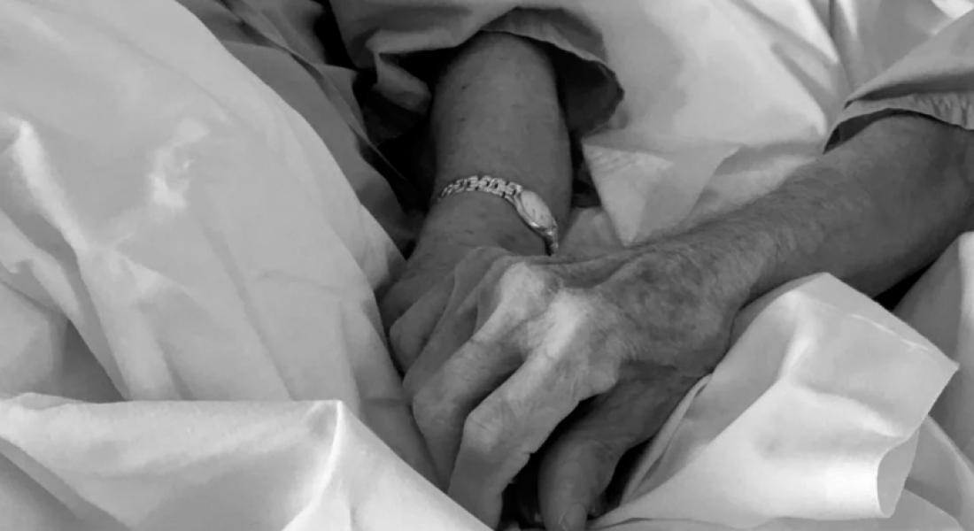 dos manos en una cama de hospital